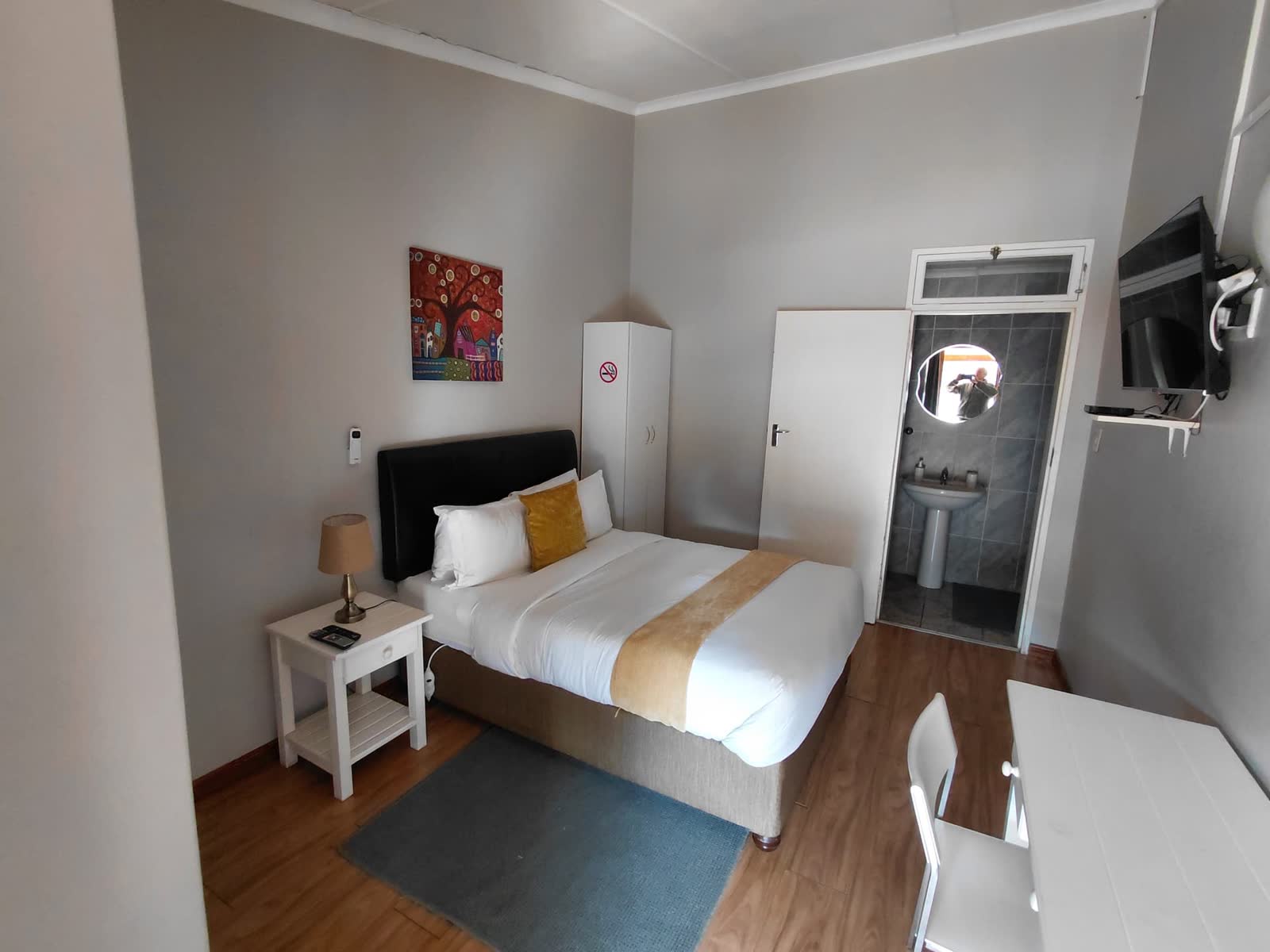 Compact guest room with double bed, wardrobe and en-suite bathroom