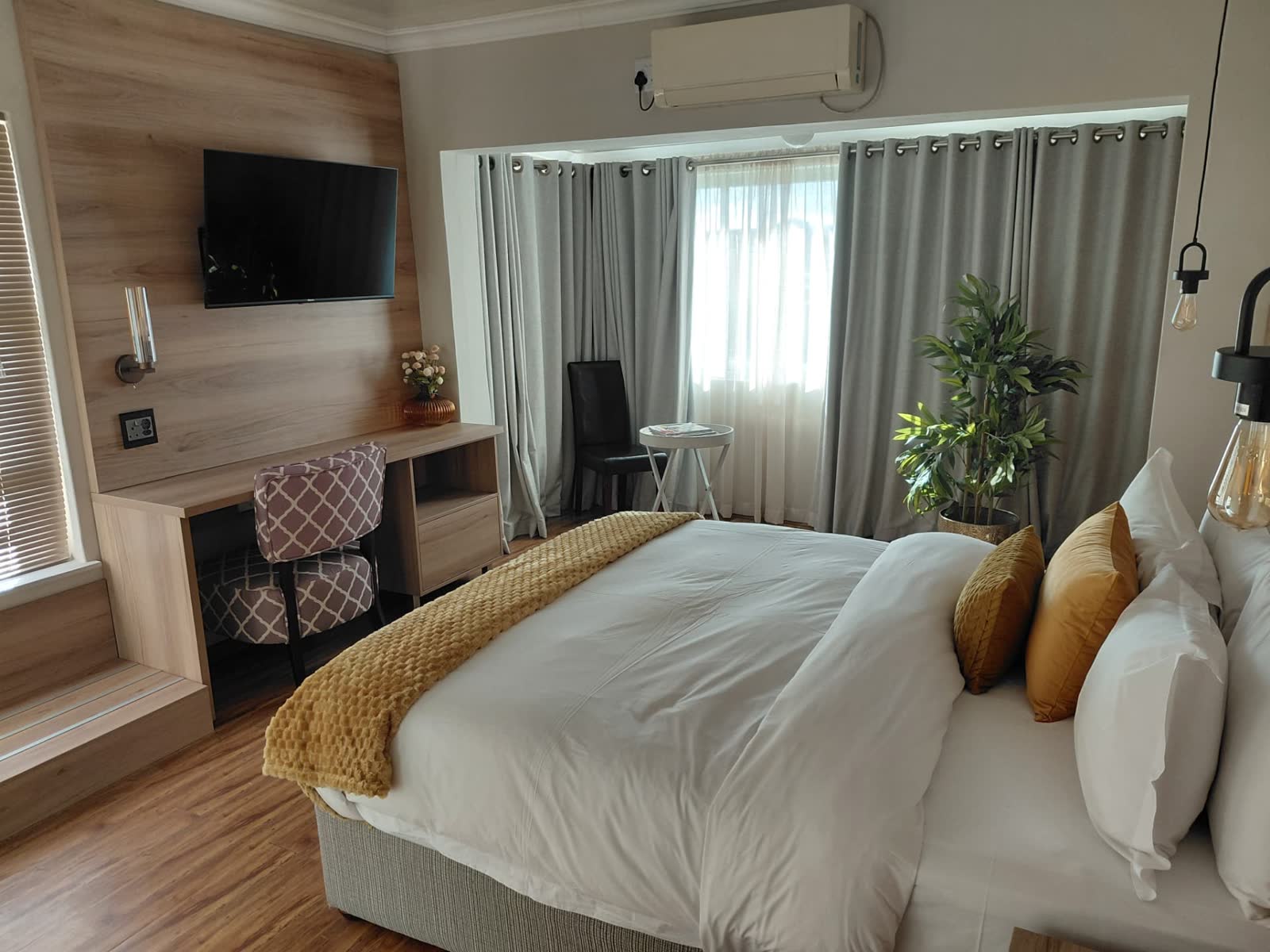 Modern king room with wood panelling, desk and mounted TV