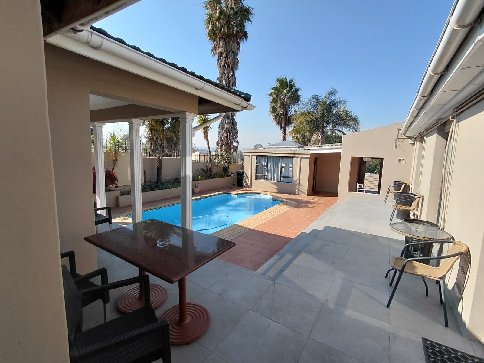 Sunny pool courtyard with sheltered outdoor seating