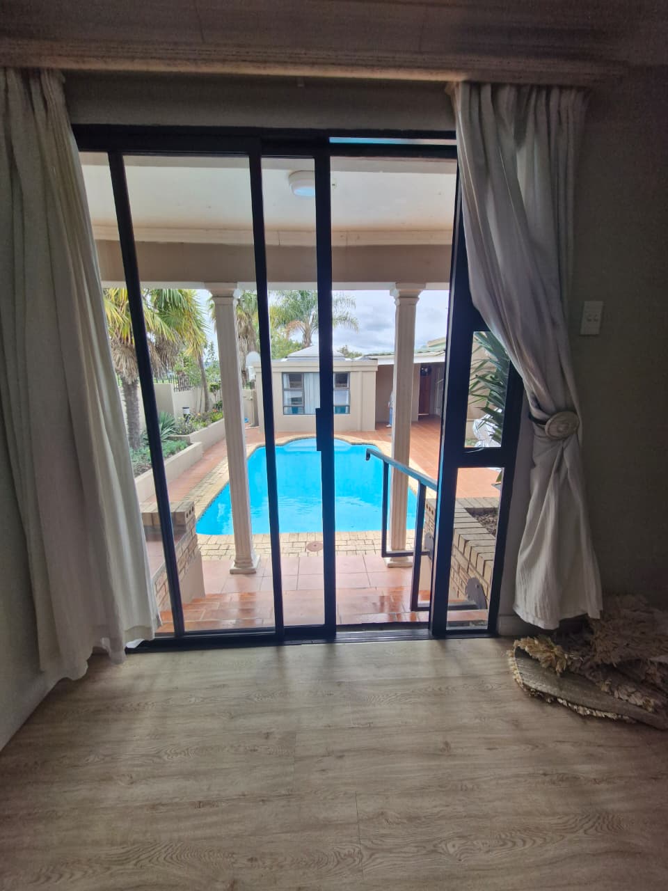 Pool view from guest room with curtains
